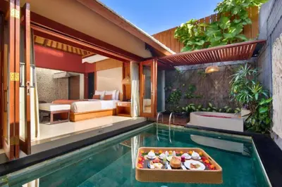 a pool with a tray of food in a hotel room at Bahira Lovely 1 BR Grand Pool Villa With Bathtub in Legian
