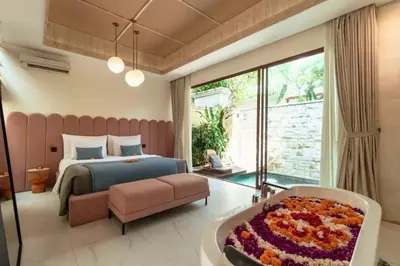 a bedroom with a bed and a large window at Emica Peaceful Royal 1 BR Pool Villa With Bathtub in Legian