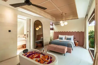 a bedroom with a bed and a bath tub at Emica Peaceful Royal 1 BR Pool Villa With Bathtub in Legian