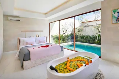 a bedroom with a bed and a tub filled with fruit at Emica Peaceful Royal 1 BR Pool Villa With Bathtub in Legian