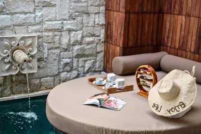 a round table with a hat and magazines on it at Evelyn Grand 1 BR Private Pool Villa With Bathtub in Legian