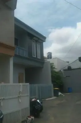 a house with a motorcycle parked in front of it at Bali Kiddy - Casa Fonte 3 BR in Denpasar
