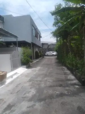 a driveway with a car parked next to a house at Bali Kiddy - Casa Fonte 3 BR in Denpasar