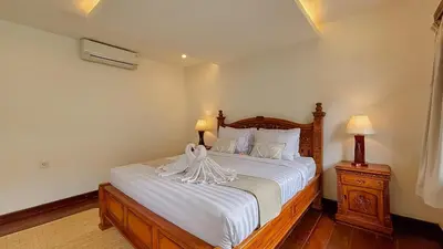 a bedroom with a bed with white sheets and two lamps at New 2BR Mahaprada Private Pool in Seminyak in Seminyak
