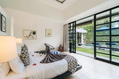 a bedroom with a bed and a large window at Modern 2BR Pool Villa in Umalas with Billiard & Long Pool in Canggu