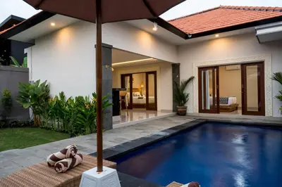 a house with a swimming pool and an umbrella at Villa Inges 1 Seminyak in Seminyak