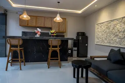 a kitchen and living room with a bar and a couch at Villa Inges 1 Seminyak in Seminyak