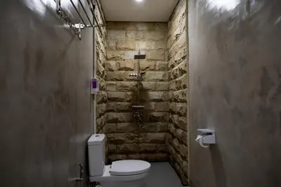 a bathroom with a toilet and a brick wall at Villa Inges 1 Seminyak in Seminyak