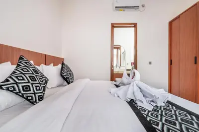 a bedroom with two beds with white sheets and pillows at Sunset Max Villa in Seminyak
