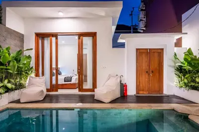 a house with a swimming pool and a bedroom at Sunset Max Villa in Seminyak