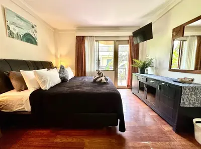 a bedroom with a bed and a couch and a television at Apartment at Jayakarta Residence 6214 in Seminyak