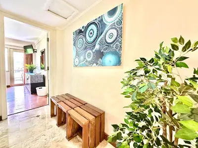 a living room with a bench and a painting on the wall at Apartment at Jayakarta Residence 6214 in Seminyak