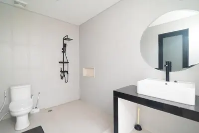 a bathroom with a white toilet and a sink at Villa nia gray 1 in Seminyak