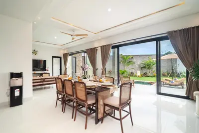 a dining room with a table and chairs at Villa nia gray 1 in Seminyak