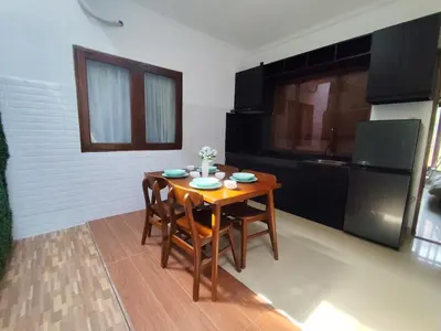 a kitchen with a wooden table and chairs in a room at Royal villa nusa dua quiet 2BR with public pool in Nusa Dua