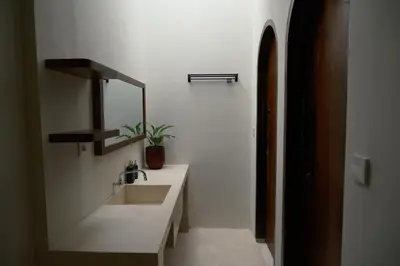 a white bathroom with a sink and a mirror at Avaya Boutique Hostel by Ayodya Beach Inn in Legian