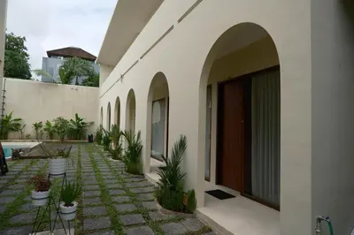 a courtyard with potted plants on the side of a building at Avaya Boutique Hostel by Ayodya Beach Inn in Legian
