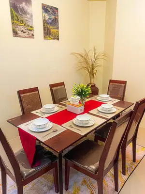 a dining room table with chairs and a red table runner at Private 5BR Jimbaran House with Pool, up to 12 Pax in Jimbaran