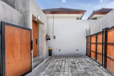 a garage with two wooden doors and a tile floor at Casa Benita 2 Villa Seminyak in Seminyak