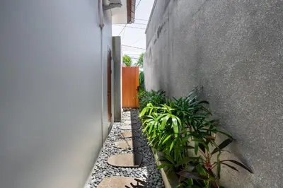 a garden with plants in a hallway next to a building at Casa Benita 2 Villa Seminyak in Seminyak
