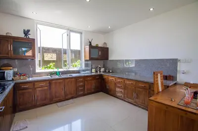 a large kitchen with wooden cabinets and a window at Villa Efes Bali in Seminyak