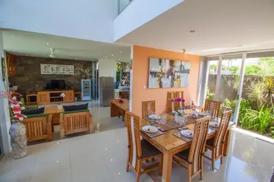 a dining room and living room with a table and chairs at Villa Efes Bali in Seminyak