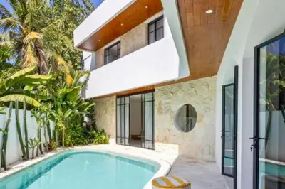 a swimming pool in front of a house at Ashlyn Elegant 4 BR Private Pool Villa in Canggu