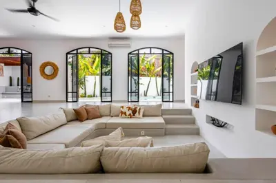 a living room with a large couch and windows at Ashlyn Elegant 4 BR Private Pool Villa in Canggu