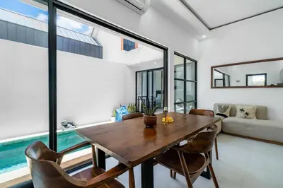 a dining room with a wooden table and chairs at Villa Paoua by BaliSuperHost in Seminyak