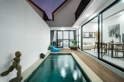 an indoor pool in a house with a living room at Villa Paoua by BaliSuperHost in Seminyak