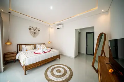 a bedroom with a bed and a flat screen tv at Villa Amani Seminyak in Seminyak