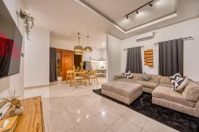 a living room with a couch and a table at 3 Bd Pvt House with big common pool and Gym & BBQ in Nusa Dua