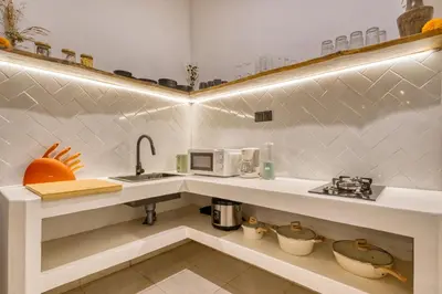 a kitchen with a sink and a microwave at 3 Bd Pvt House with big common pool and Gym & BBQ in Nusa Dua