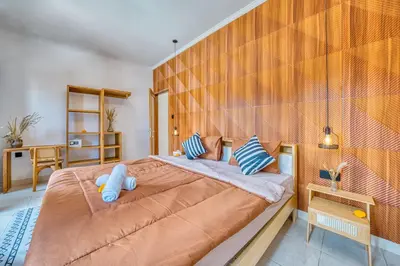 a bedroom with a large bed with blue pillows at 3 Bd Pvt House with big common pool and Gym & BBQ in Nusa Dua