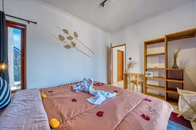 a bedroom with a large pink bed with flowers on it at 3 Bd Pvt House with big common pool and Gym & BBQ in Nusa Dua