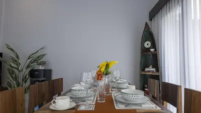 a dining room table with plates and bowls and glasses at 3BR Private Pool Villa in Central Seminyak - Walk to Cafés & Shops in Seminyak