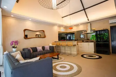 a living room with a couch and a kitchen at Amazing Private Pool Villa 2BR in Seminyak Bali in Kerobokan