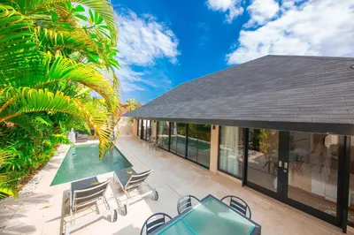 an outdoor patio with chairs and a pool at Amazing Private Pool Villa 2BR in Seminyak Bali in Kerobokan