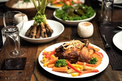 a table with plates of food on a wooden table at Villa Abagram Anam in Seminyak