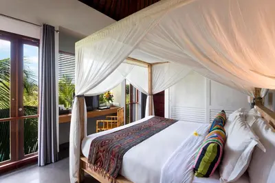 a bedroom with a white bed with a canopy at Villa Abagram Anam in Seminyak