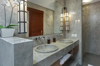 two sinks in a bathroom with two mirrors at Villa Abagram Anam in Seminyak