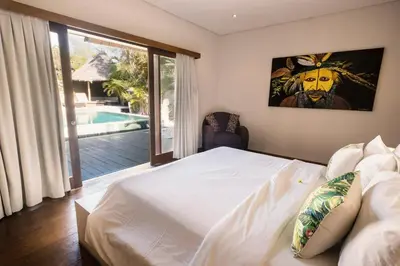 a bedroom with a bed and a view of a pool at Seminyak Villa in Seminyak