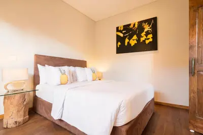 a bedroom with a large bed with white sheets at Seminyak Villa in Seminyak
