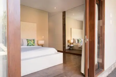 a bedroom with a white bed and a mirror at Seminyak Villa in Seminyak