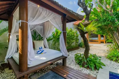 a room with a canopy bed in a garden at Heart of Seminyak, 2Br, Sleeps 4, Walk to Bintang in Seminyak