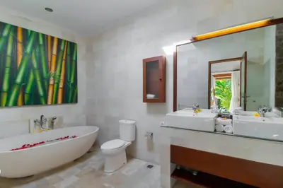 a bathroom with a tub and a toilet and a large mirror at Heart of Seminyak, 2Br, Sleeps 4, Walk to Bintang in Seminyak