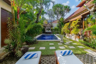 a backyard with a swimming pool and a house at Heart of Seminyak, 2Br, Sleeps 4, Walk to Bintang in Seminyak
