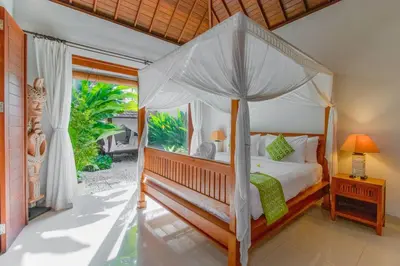 a bedroom with a canopy bed and a balcony at Heart of Seminyak, 2Br, Sleeps 4, Walk to Bintang in Seminyak