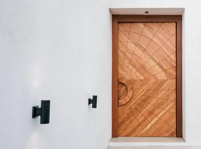 a wooden door in a white wall at Villa Dorithis Umalas in Kerobokan