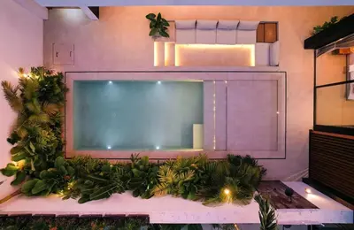 a large flat screen tv on a wall with plants at Villa Dorithis Umalas in Kerobokan